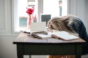 slumped over desk